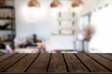 Seçilen odak boş kahverengi ahşap masa ve kafeterya bokeh görüntü ile arka plan bulanıklık. Fotomontaj veya ürün ekran.