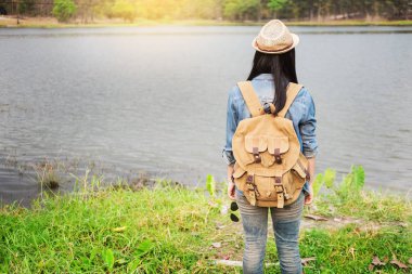 Kendine güvenen kadın vahşi bir göl kıyısında arka planda, Dağları ile poz turistik şaşırtıcı.