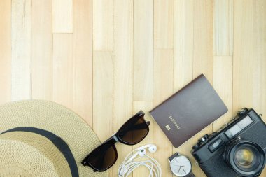 Gerekli seyahat aksesuarları, tropikal yaprak alanı olan ahşap arka plan üzerinde öğeleri. Seyahat tatil kavramı düz moda stil, üstten görünüm yatıyordu.