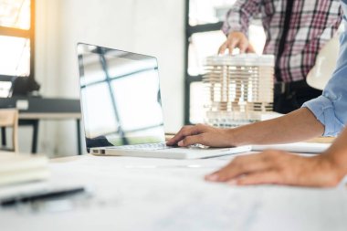 Yakın çekim, kişinin mühendis el çizim planı üzerinde mavi baskı mimar ekipmanlı, mimarlar tablo, takım çalışması ve iş akışı inşaat kavramı tartışmaya.