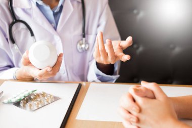 Tablet ilacın tutan el doktor ve hasta hastane odasında açıklamak.