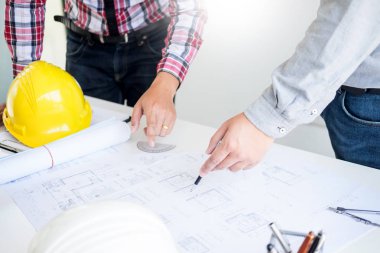 Yakın çekim, kişinin mühendis el çizim planı üzerinde mavi baskı mimar ekipmanlı, mimarlar tablo, takım çalışması ve iş akışı inşaat kavramı tartışmaya.