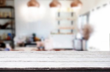 Seçilen odak boş kahverengi ahşap masa ve kafeterya bokeh görüntü ile arka plan bulanıklık. Fotomontaj veya ürün ekran.