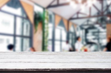 Seçilen odak boş kahverengi ahşap masa ve kafeterya bokeh görüntü ile arka plan bulanıklık. Fotomontaj veya ürün ekran.