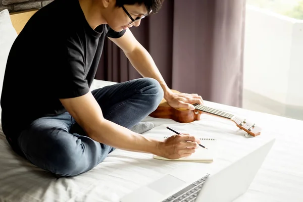 Glad Ung Asiatisk Man Spela Ukulele Sitter Sängen Sovrummet — Stockfoto