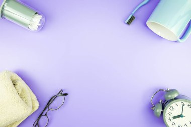 madeni eşya saat düz yatıyordu kompozisyon diş fırçası gözlük, mavi ve mor menekşe kavramı üzerinde havlu ve terlik üstten görünüm