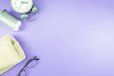 madeni eşya saat düz yatıyordu kompozisyon diş fırçası gözlük, mavi ve mor menekşe kavramı üzerinde havlu ve terlik üstten görünüm