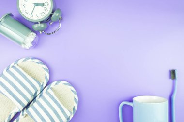 madeni eşya saat düz yatıyordu kompozisyon diş fırçası gözlük, mavi ve mor menekşe kavramı üzerinde havlu ve terlik üstten görünüm