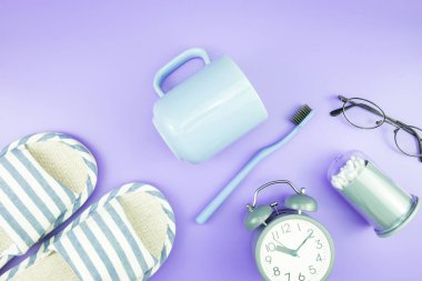 madeni eşya saat düz yatıyordu kompozisyon diş fırçası gözlük, mavi ve mor menekşe kavramı üzerinde havlu ve terlik üstten görünüm