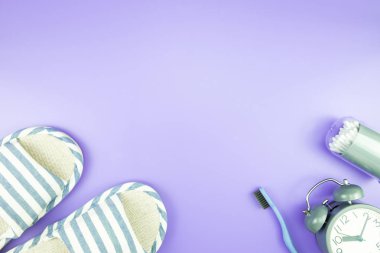madeni eşya saat düz yatıyordu kompozisyon diş fırçası gözlük, mavi ve mor menekşe kavramı üzerinde havlu ve terlik üstten görünüm