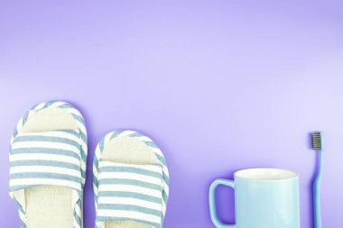 madeni eşya saat düz yatıyordu kompozisyon diş fırçası gözlük, mavi ve mor menekşe kavramı üzerinde havlu ve terlik üstten görünüm