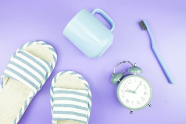 madeni eşya saat düz yatıyordu kompozisyon diş fırçası gözlük, mavi ve mor menekşe kavramı üzerinde havlu ve terlik üstten görünüm
