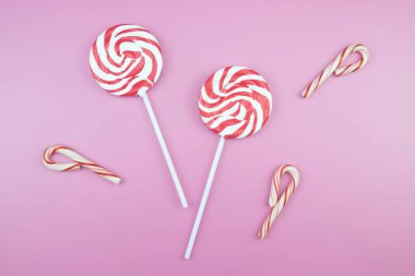 Üstten görünüm lezzetli iştah açıcı kavramı, en az tatlı tedavi girdap Candy lolipop hatmi renkli desen pembe pastel zemin üzerine yat ve uzay kopyalayın