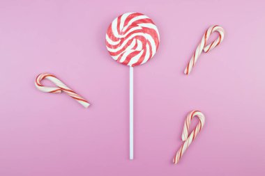 Üstten görünüm lezzetli iştah açıcı kavramı, en az tatlı tedavi girdap Candy lolipop hatmi renkli desen pembe pastel zemin üzerine yat ve uzay kopyalayın