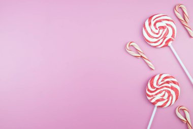 Üstten görünüm lezzetli iştah açıcı kavramı, en az tatlı tedavi girdap Candy lolipop hatmi renkli desen pembe pastel zemin üzerine yat ve uzay kopyalayın