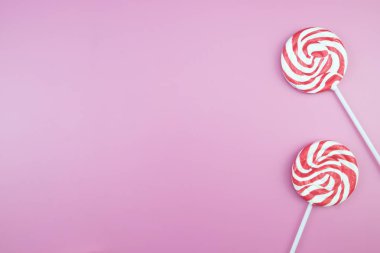 Üstten görünüm lezzetli iştah açıcı kavramı, en az tatlı tedavi girdap Candy lolipop hatmi renkli desen pembe pastel zemin üzerine yat ve uzay kopyalayın