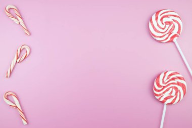 Üstten görünüm lezzetli iştah açıcı kavramı, en az tatlı tedavi girdap Candy lolipop hatmi renkli desen pembe pastel zemin üzerine yat ve uzay kopyalayın