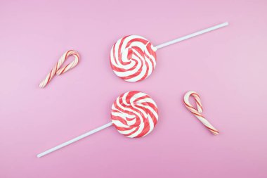 Üstten görünüm lezzetli iştah açıcı kavramı, en az tatlı tedavi girdap Candy lolipop hatmi renkli desen pembe pastel zemin üzerine yat ve uzay kopyalayın