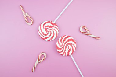 Üstten görünüm lezzetli iştah açıcı kavramı, en az tatlı tedavi girdap Candy lolipop hatmi renkli desen pembe pastel zemin üzerine yat ve uzay kopyalayın