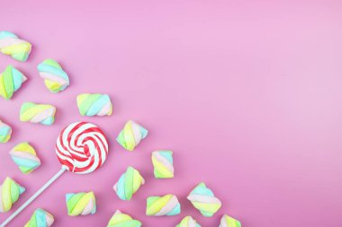 Üstten görünüm lezzetli iştah açıcı kavramı, en az tatlı tedavi girdap Candy lolipop hatmi renkli desen pembe pastel zemin üzerine yat ve uzay kopyalayın