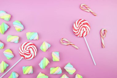 Üstten görünüm lezzetli iştah açıcı kavramı, en az tatlı tedavi girdap Candy lolipop hatmi renkli desen pembe pastel zemin üzerine yat ve uzay kopyalayın