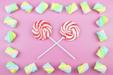 Üstten görünüm lezzetli iştah açıcı kavramı, en az tatlı tedavi girdap Candy lolipop hatmi renkli desen pembe pastel zemin üzerine yat ve uzay kopyalayın
