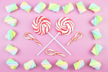 Üstten görünüm lezzetli iştah açıcı kavramı, en az tatlı tedavi girdap Candy lolipop hatmi renkli desen pembe pastel zemin üzerine yat ve uzay kopyalayın