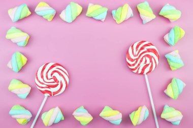 Üstten görünüm lezzetli iştah açıcı kavramı, en az tatlı tedavi girdap Candy lolipop hatmi renkli desen pembe pastel zemin üzerine yat ve uzay kopyalayın