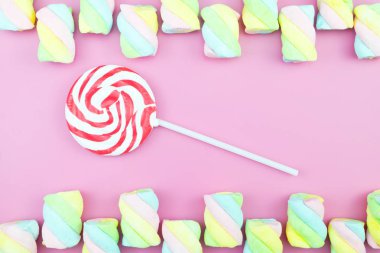 Üstten görünüm lezzetli iştah açıcı kavramı, en az tatlı tedavi girdap Candy lolipop hatmi renkli desen pembe pastel zemin üzerine yat ve uzay kopyalayın