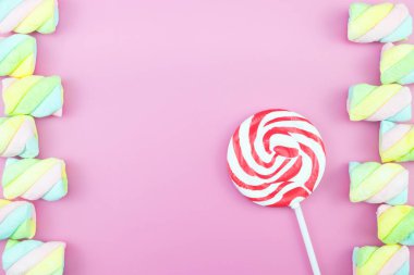 Üstten görünüm lezzetli iştah açıcı kavramı, en az tatlı tedavi girdap Candy lolipop hatmi renkli desen pembe pastel zemin üzerine yat ve uzay kopyalayın