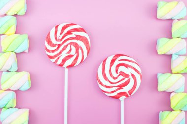 Üstten görünüm lezzetli iştah açıcı kavramı, en az tatlı tedavi girdap Candy lolipop hatmi renkli desen pembe pastel zemin üzerine yat ve uzay kopyalayın