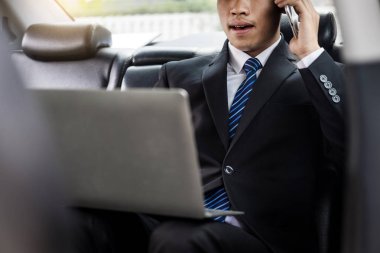 Çekici genç iş adamı. Arabada cep telefonu kullanıyor..