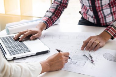 Yakın çekim, kişinin mühendis el çizim planı üzerinde mavi baskı mimar ekipmanlı, mimarlar tablo, takım çalışması ve iş akışı inşaat kavramı tartışmaya.