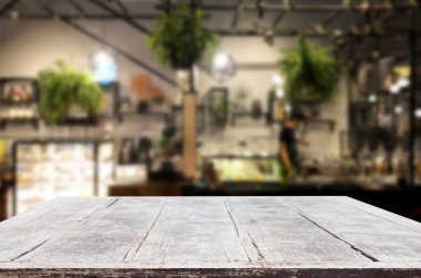 Seçilmiş odak noktası boş kahverengi ahşap masa ve kafeterya veya restoranın arka planı bokeh görüntülü bulanık. Fotomontaj ya da ürün gösterimi için.
