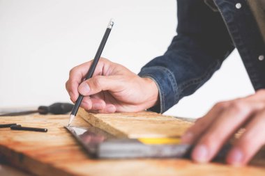 Marangoz, marangozluk planları eser dikkatle bakarak çalışma. Onun işyerinde başarılı bir girişimci olduğunu. Destekler üzerinde inşaat alanında iş kesici ile çivi çekiç