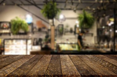 Seçilmiş odak noktası boş kahverengi ahşap masa ve kafeterya veya restoranın arka planı bokeh görüntülü bulanık. Fotomontaj ya da ürün gösterimi için.