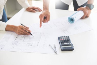 Yakın çekim, kişinin mühendis el çizim planı üzerinde mavi baskı mimar ekipmanlı, mimarlar tablo, takım çalışması ve iş akışı inşaat kavramı tartışmaya.