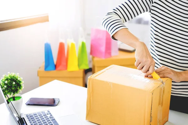 e-commerce delivery concept and online selling start up small business owner packing in the card box at workplace. freelance woman seller prepare product for packaging process at shop.