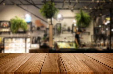 Seçilmiş odak noktası boş kahverengi ahşap masa ve kafeterya veya restoranın arka planı bokeh görüntülü bulanık. Fotomontaj ya da ürün gösterimi için.