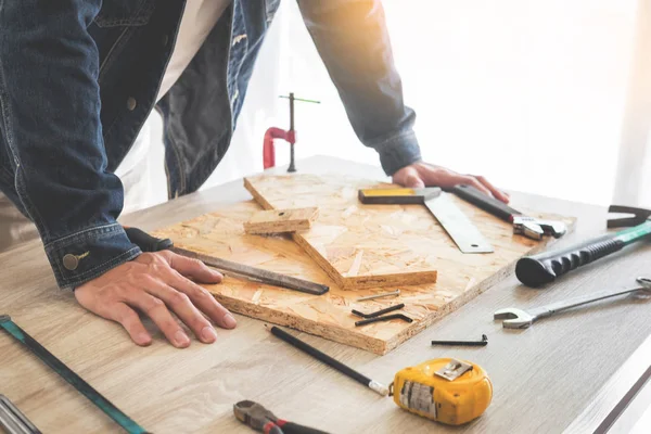 Marangoz, marangozluk planları eser dikkatle bakarak çalışma. Onun işyerinde başarılı bir girişimci olduğunu. Destekler üzerinde inşaat alanında iş kesici ile çivi çekiç