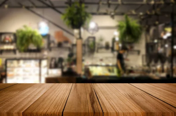 Seçilmiş odak noktası boş kahverengi ahşap masa ve kafeterya veya restoranın arka planı bokeh görüntülü bulanık. Fotomontaj ya da ürün gösterimi için.