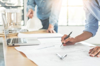 Yakın çekim, kişinin mühendis el çizim planı üzerinde mavi baskı mimar ekipmanlı, mimarlar tablo, takım çalışması ve iş akışı inşaat kavramı tartışmaya.