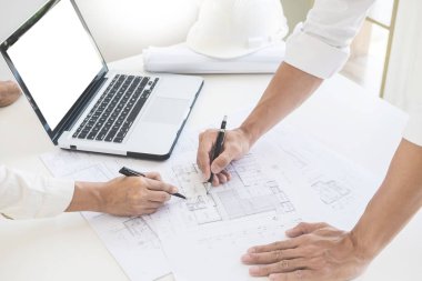 Yakın çekim, kişinin mühendis el çizim planı üzerinde mavi baskı mimar ekipmanlı, mimarlar tablo, takım çalışması ve iş akışı inşaat kavramı tartışmaya.