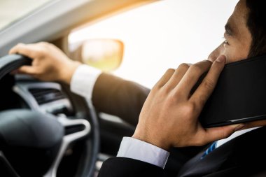 Çekici genç iş adamı. Arabada cep telefonu kullanıyor..