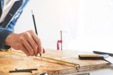 Marangoz, marangozluk planları eser dikkatle bakarak çalışma. Onun işyerinde başarılı bir girişimci olduğunu. Destekler üzerinde inşaat alanında iş kesici ile çivi çekiç
