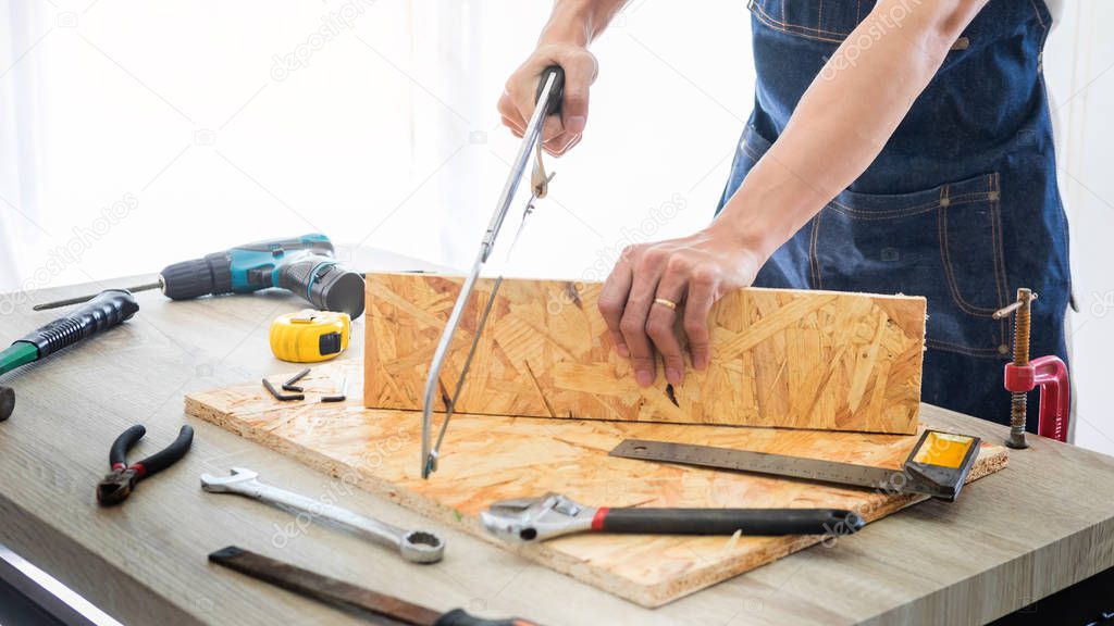 Carpenter working carefully looking at the plans work in carpentry. He is successful entrepreneur at his workplace. hammering a nail Supports On Building Site work with cutter