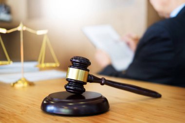 Avukat Yargıç ahşap Resepsiyon arka plan üzerinde çalışma salonunda masada belgeleri okuma. Altın ağırlık tokmak. ve soundblock adalet 