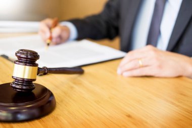 Avukat Yargıç ahşap Resepsiyon arka plan üzerinde çalışma salonunda masada belgeleri okuma. Altın ağırlık tokmak. ve soundblock adalet 