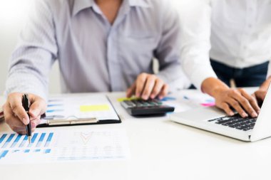 Ofiste çalışan işadamı bilgisayarında, tabletinde ve çalışma masasında veri dokümanlarıyla çalışıyor..