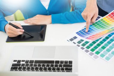 Yaratıcı veya pantone renk örneği ve planları ofis masası üzerinde bina ile iç tasarımcılar ekip çalışması mimarlar tasarım projesi bir masaüstü bilgisayar ve bazı renk örneklerini kullanarak seçim seçerek renk örnekleri